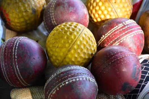 Training cricket sport equipments on floor, leather ball, gloves and bat, soft and selective focus on ball. photo