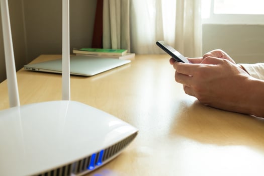 Men hand using smartphone device to connect to wifi network from internet router. Broadband high speed internet network technology for access to many application and services online. photo