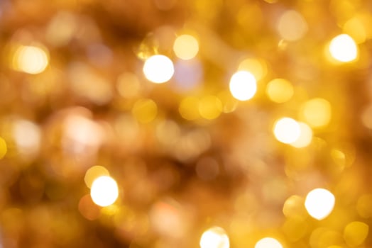 Blurred defocus shot of yellow or golden decorating light bokeh. That people decorate during Christmas celebration period. Ideal for wallpaper and background. photo