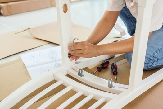 Man assembling white chair furniture at home photo