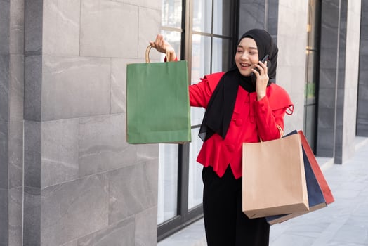 Beautiful East Asian Islamic women wearing hijab. Smile and feeling happy and holding many shopping bags walking in urban city area or department store. People lifestyle concept. photo
