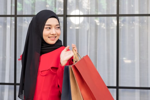 Beautiful East Asian Islamic women wearing hijab. Smile and feeling happy and holding many shopping bags walking in urban city area or department store. People lifestyle concept. photo