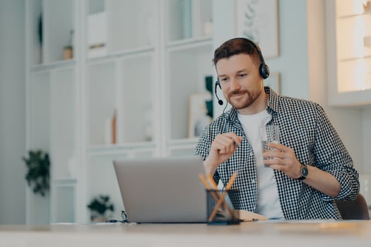 Education and e learning concept. Satisfied busy man focused at laptop display watches educational webinar listens audio course via headphones sits at desktop enjoys virtual studying with tutor photo