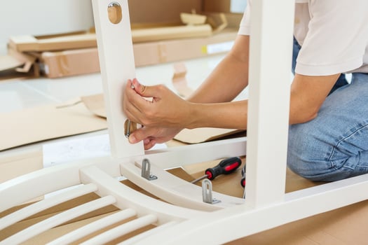 Man assembling white chair furniture at home photo