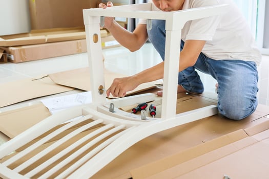 Man assembling white chair furniture at home photo