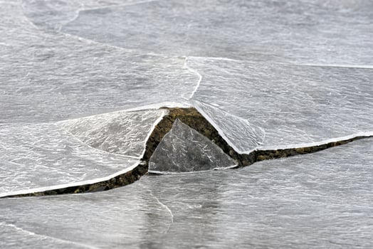 Rock cracking through the ice in Vagspollen in the Lofoten Islands, Norway in the winter. photo