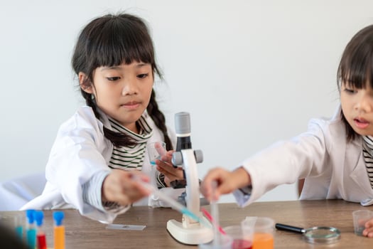 education, science, chemistry and children concept - kids or students with test tube making experiment at school laboratory photo