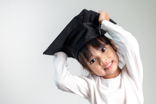 Happy Asian school kid graduate in graduation cap photo