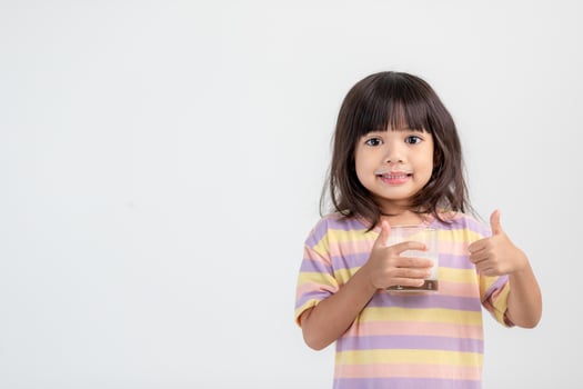 Smiling of Asian girl with a glass of milk photo