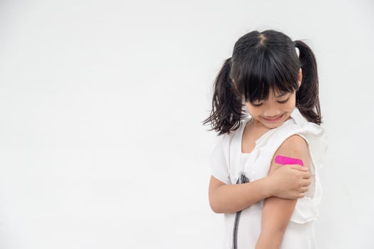 Asian little girl showing his arm after got vaccinated or inoculation, child immunization, covid delta vaccine concept photo