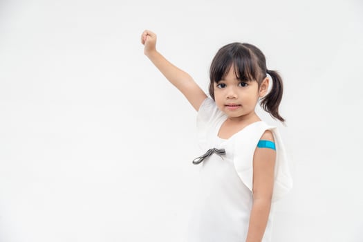 Asian little girl showing his arm after got vaccinated or inoculation, child immunization, covid delta vaccine concept photo