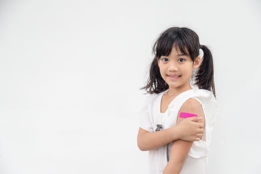 Asian little girl showing his arm after got vaccinated or inoculation, child immunization, covid delta vaccine concept photo