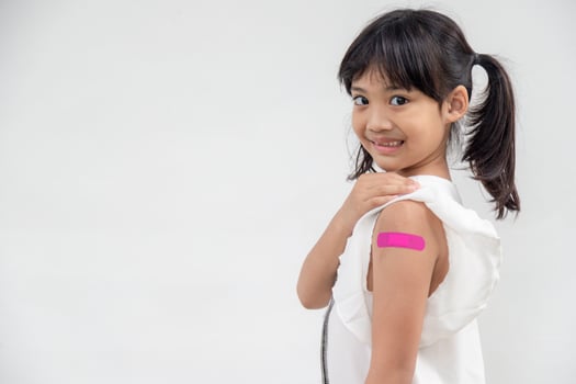 Asian little girl showing his arm after got vaccinated or inoculation, child immunization, covid delta vaccine concept photo