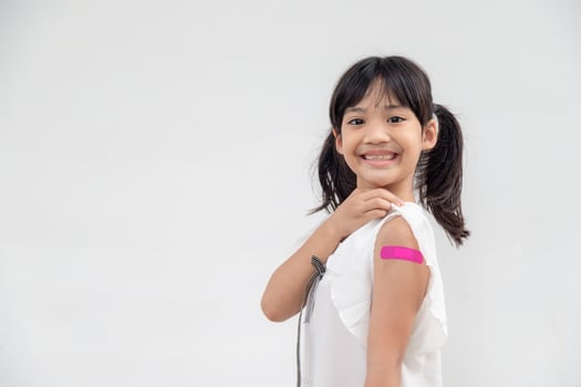 Asian little girl showing his arm after got vaccinated or inoculation, child immunization, covid delta vaccine concept photo