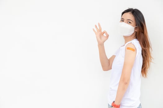 Asian Women Show Bandage On Arm. Happy Asian Woman Feels Good After Received Vaccine On White Background. photo