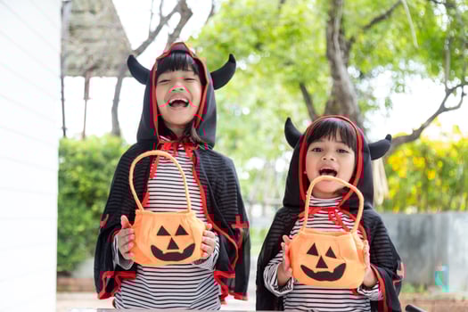 happy Halloween. Sibling girl in suits and with pumpkins in the home photo