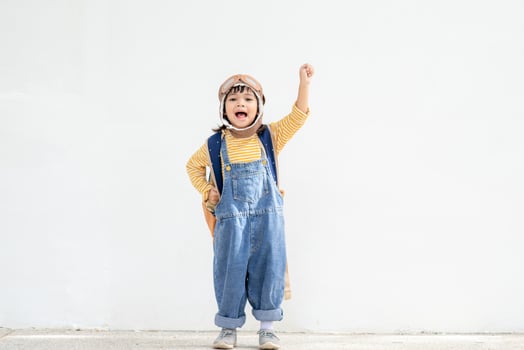 A cute little girl dressed in a cap and glasses of a pilot. The child dreams of becoming a pilot. photo