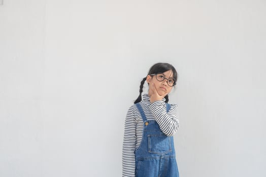 Cute Asian small girl wearing glasses and thinking photo