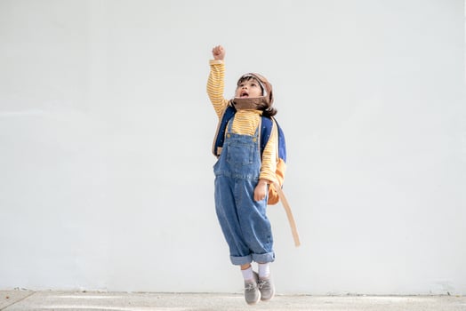 A cute little girl dressed in a cap and glasses of a pilot. The child dreams of becoming a pilot. photo