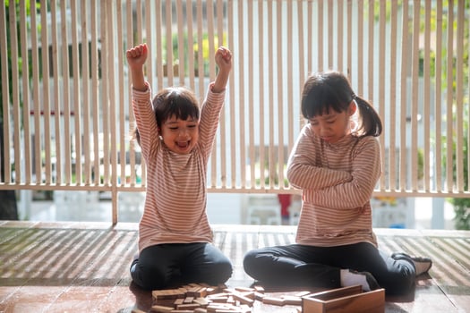 two Asian girls playing wooden stacks at home photo