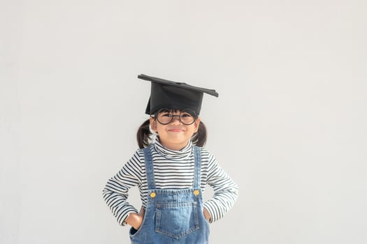 Happy Asian school kid graduate in graduation cap photo