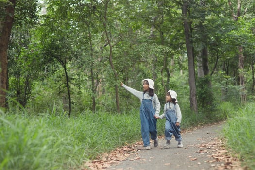 Children are heading to the family campsite in the forest Walk along the tourist route. Camping road. Family travel vacation concept. photo