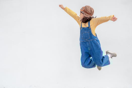 dreams of flight little child girl playing with a pilot hat on white background photo