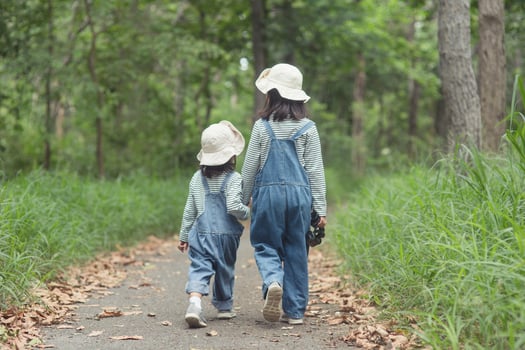 Children are heading to the family campsite in the forest Walk along the tourist route. Camping road. Family travel vacation concept. photo