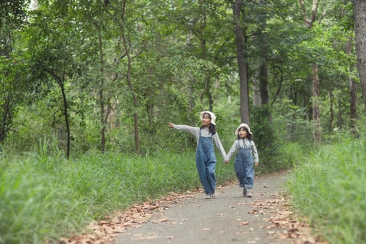 Children are heading to the family campsite in the forest Walk along the tourist route. Camping road. Family travel vacation concept. photo
