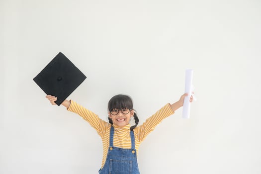 children girl wearing a graduate cap over white background very happy and excited doing winner gesture with arms raised, smiling and screaming for success. Celebration concept. photo