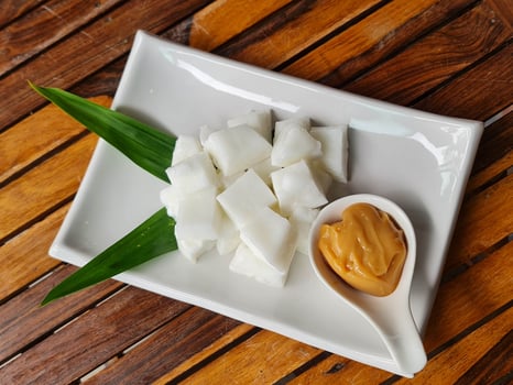 Tasty coconut milk serve with caramel sauce decorated with flower is on wooden table photo