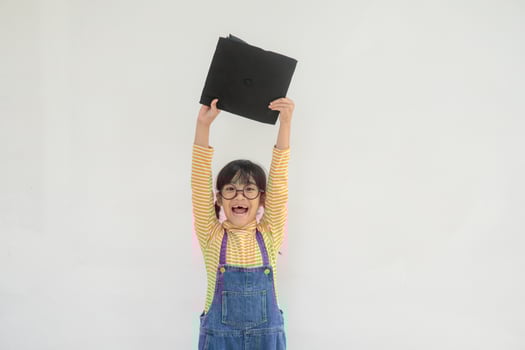 children girl wearing a graduate cap over white background very happy and excited doing winner gesture with arms raised, smiling and screaming for success. Celebration concept. photo