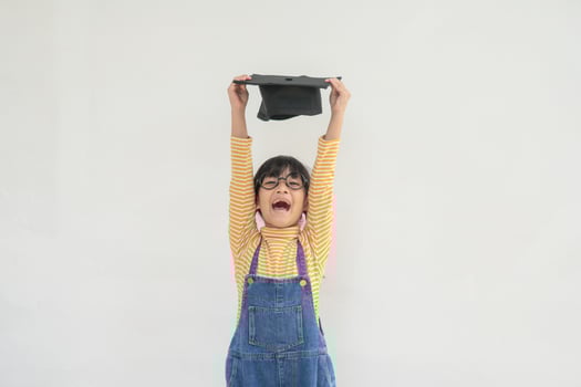 children girl wearing a graduate cap over white background very happy and excited doing winner gesture with arms raised, smiling and screaming for success. Celebration concept. photo