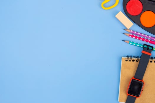 Stationery accessory on blue background. School supplies, pencils, paints, and color books, on blue background with copy space. Education and freelancer work concept photo