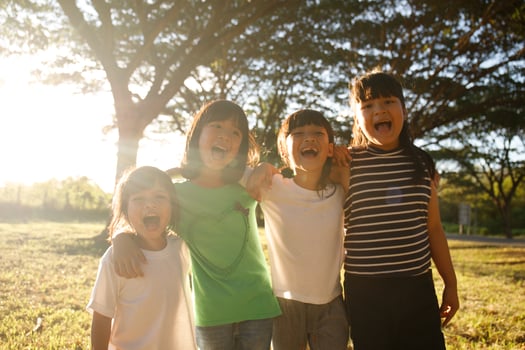 Group of kindergarten kids friends arm around and smiling fun With sunset photo