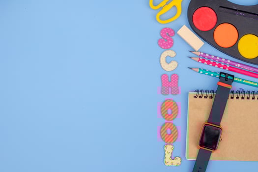 Stationery accessory on blue background. School supplies, pencils, paints, and color books, on blue background with copy space. Education and freelancer work concept photo