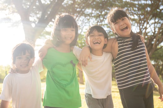 Group of kindergarten kids friends arm around and smiling fun With sunset photo