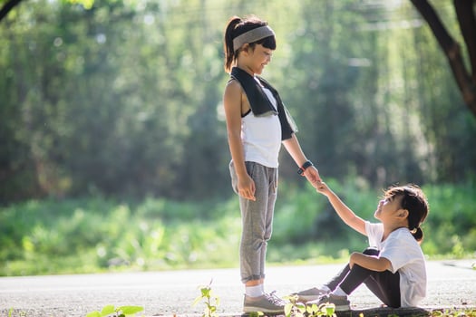 Cute asian girl give hand to help sister accident during running photo