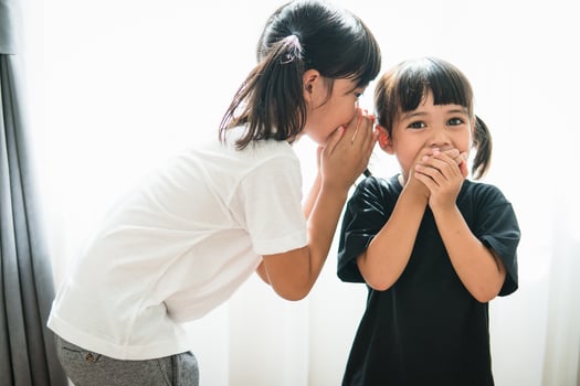 happy little Asian siblings sharing secrets photo