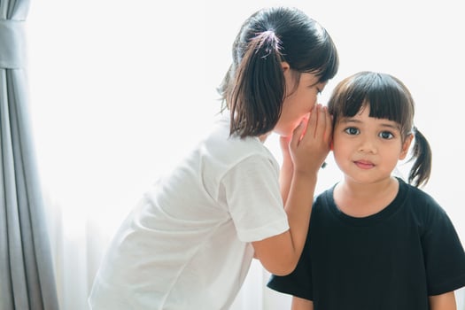 happy little Asian siblings sharing secrets photo