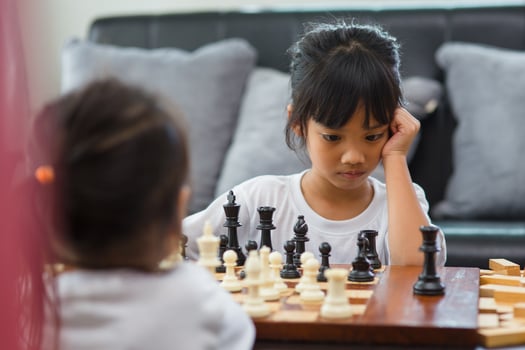 Two cute children playing chess at home photo