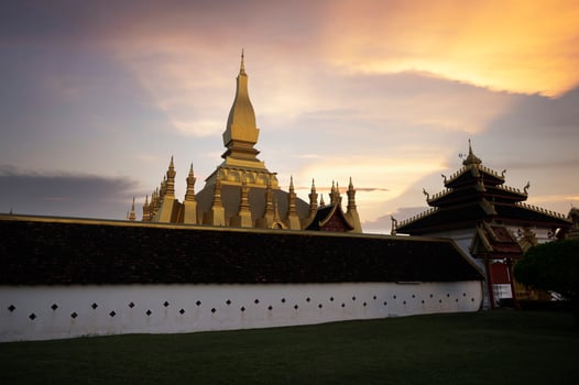 Laos Travel Landmark, Golden Chedi, Wat Phra That Luang at sunset in Vientiane photo