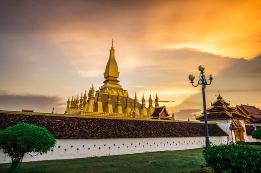 Laos Travel Landmark, Golden Chedi, Wat Phra That Luang at sunset in Vientiane photo