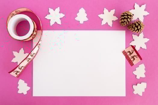 Top view on the Christmas decorations and white sheet of paper on the pink background with copy space. photo