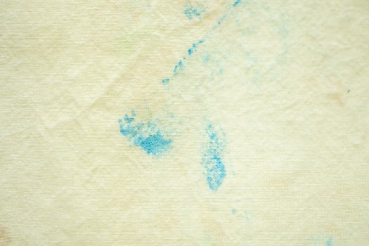 dirty color stain on yellow fabric texture background photo