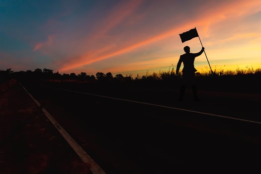 Victory concept, a silhouette of a man standing in the sunset sky. photo