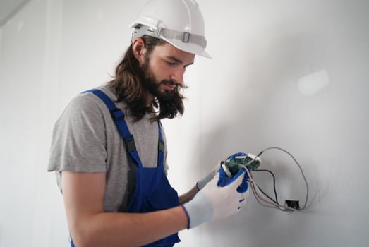 A man in overalls and hard hat is working on a wall photo