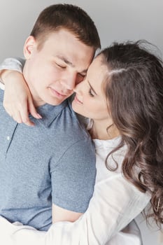Romantic sexy couple in love having nice time together. Young woman hugging boyfriend, white background photo