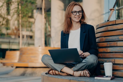 Pleased pretty redhead woman learns educational course on laptop computer photo