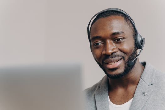 Young pleased african american man callcenter agent talking with client, consulting customer online photo